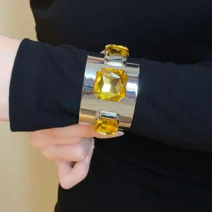 Detailed view of silver cuff bracelet featuring three large square yellow gemstones
