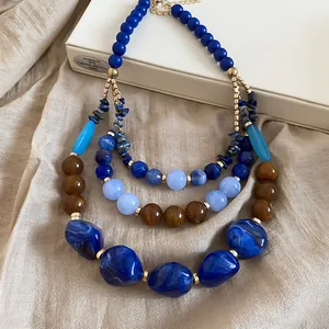 Gros plan d'un collier ethnique multicouche avec des perles en résine bleues et brunes