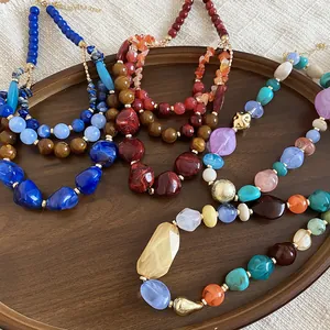 Gros plan de colliers en perles de résine acrylique vibrants au design rétro ethnique