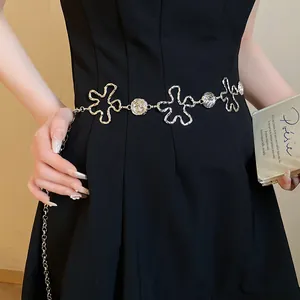 Gros plan d'une chaîne de taille vintage en métal argenté fleuri