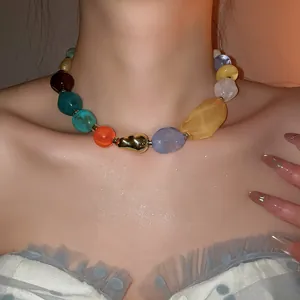 Détail rapproché d'un collier de perles en résine acrylique colorée sur un mannequin