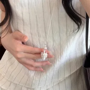Primo piano di una collana in argento in stile coreano con ciondolo a fiore bianco