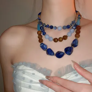 Vue détaillée d'un collier ethnique à trois rangs avec perles en résine bleues et brunes