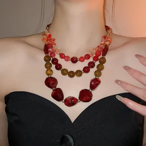 Vue détaillée en gros plan du collier à plusieurs rangs en résine acrylique rouge