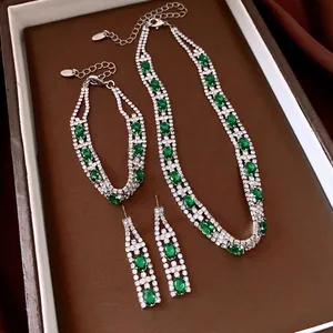 Set di gioielli vintage con pietre verdi ovali e zirconi su un vassoio