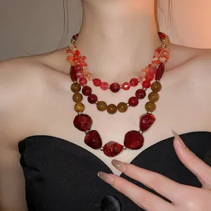 Vue détaillée d'un collier multicouche de style ethnique avec perles en résine rouge et ambre