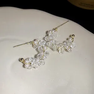Detailed macro view showing the glass beads and pearl texture of C-shaped earrings
