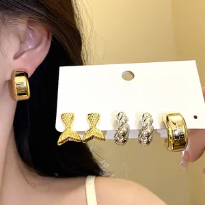 Primer plano de un conjunto de pendientes vintage dorados y plateados, varios estilos.