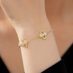 Elegant gold-plated clover bracelet with sparkling zirconia stones on a model's wrist