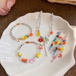 Colorful resin flower beaded jewelry set featuring necklace, bracelets, and earrings.