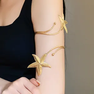 Elegant gold starfish arm cuff jewelry worn on the upper arm for a summer beach look