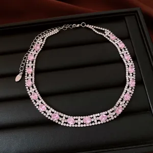 Elegante collana a tre fili con pietre rosa ovali e cristalli trasparenti su vassoio nero