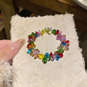 Detailed view of a multi-colored faceted bead bracelet on handmade paper texture