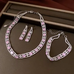 Dettaglio di un set di gioielli vintage con zirconi ovali rosa e strass argentati lucenti