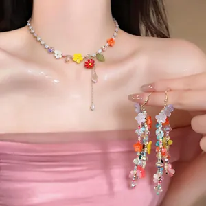 Close-up of colorful resin flower beaded necklace and matching tassel earrings.
