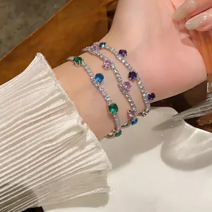 Detailed view of layered zircon bracelets with colorful round-cut stones on wrist