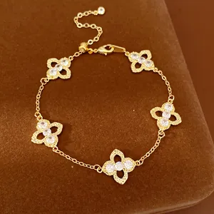 Detail view of gold clover bracelet with sparkling zircon stones and hollow texture