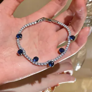 Close-up of a silver-toned bracelet featuring sparkling white zircons and deep blue gemstone accents