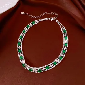 Vista dettagliata di una collana vintage a doppio filo con pietre ovali verdi e strass.