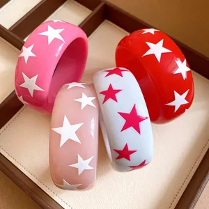 Detail shot of various resin bangles with star patterns in pink red and white