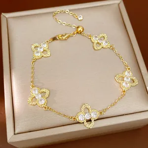 Detailed close-up of gold-plated clover bracelet with zircon-encrusted motifs
