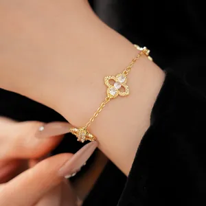 Detailed view of a gold-toned hollow clover bracelet with sparkling cubic zirconia stones.