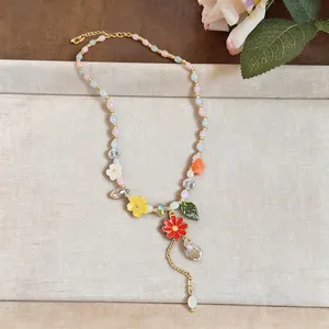 Detailed close-up of a vibrant beaded necklace featuring resin flower and leaf charms