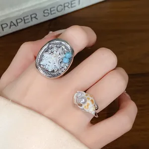 Vista dettagliata di anelli in argento con conchiglie e perle sulla mano di una modella