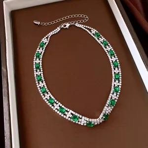 Primo piano di una collana vintage a più fili con zirconi ovali verdi e strass di cristallo.