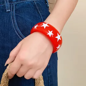Detailed shot of a red resin star bangle worn on the wrist for fashion styling