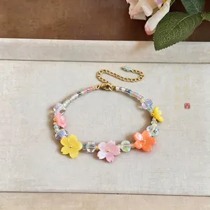 Detailed view of a handmade colorful resin flower beaded bracelet on a neutral tray.