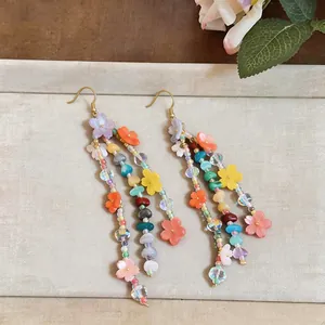Detailed view of handmade colorful resin flower dangle earrings with vibrant beaded tassels.