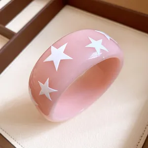 Macro view of pink resin bangle with detailed white star patterns for women jewelry