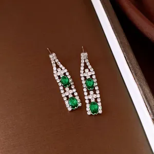 Dettaglio di orecchini vintage a goccia con zirconi verdi ovali e cristalli brillanti