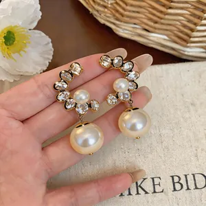 Detailed macro shot of French vintage pearl drop earrings with sparkling rhinestones