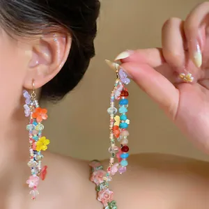 Detail shot of long colorful resin flower beaded dangle earrings for a vibrant summer look.