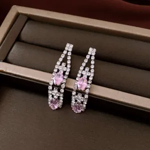 Primo piano di orecchini vintage con pietre rosa ovali e strass brillanti