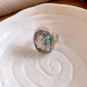 Macro dettaglio di un anello in argento regolabile con vera conchiglia e perline azzurre.
