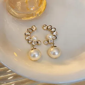 Detailed close-up of elegant vintage French style pearl earrings with crystal accents.