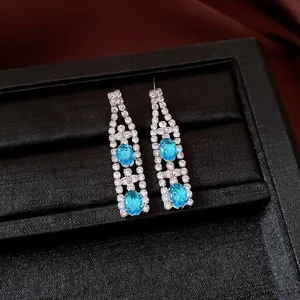 Primo piano dettagliato di orecchini a pendente vintage in argento con pietre blu e zirconi