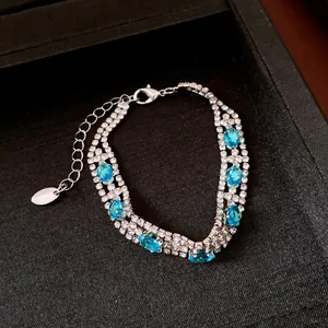 Dettaglio di un bracciale vintage in argento con pietre blu ovali e strass luccicanti