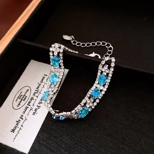 Dettaglio macro di un set di gioielli vintage con pietre blu e zirconi scintillanti