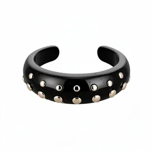 Elegant black resin open cuff bracelet featuring gold-tone round rivet studs design.