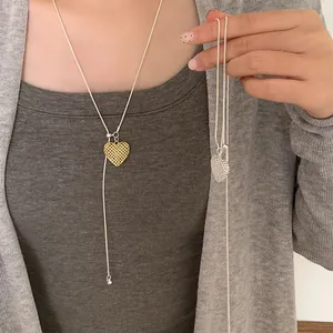 Close-up detail of hollow heart pendant necklace with intricate mesh texture on model