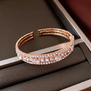 Elegante brazalete multicapa de oro rosa con cristales brillantes y diseño de apertura