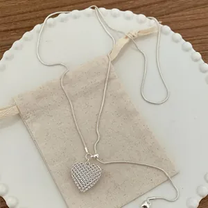 Exquisite hollow mesh heart pendant necklace in silver for a minimalist look.