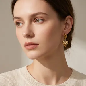 Elegant gold heart earrings with knot detail worn by a model in close-up