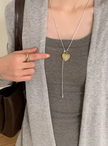Model wearing a delicate gold hollow heart pendant necklace with a minimalist cord.