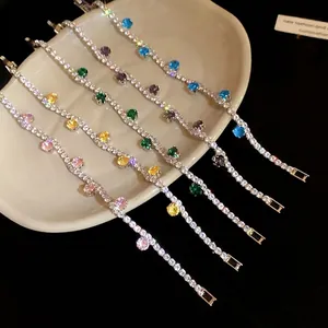 Sparkling silver tennis bracelets with colorful round zircons arranged on a white plate