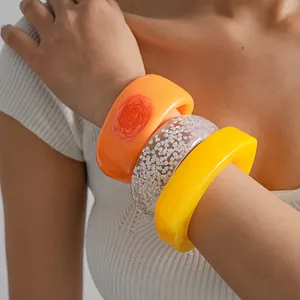 Close-up detail of colorful irregular geometric resin bangles in dopamine style